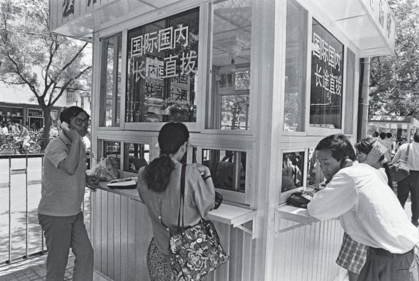 Chinese residents making long distance phone calls from a phone booth. 