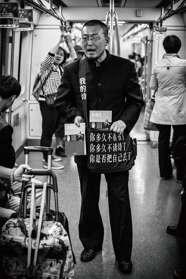 A Chinese poet tries selling copies of his book and encourages people to read more while on a subway. 